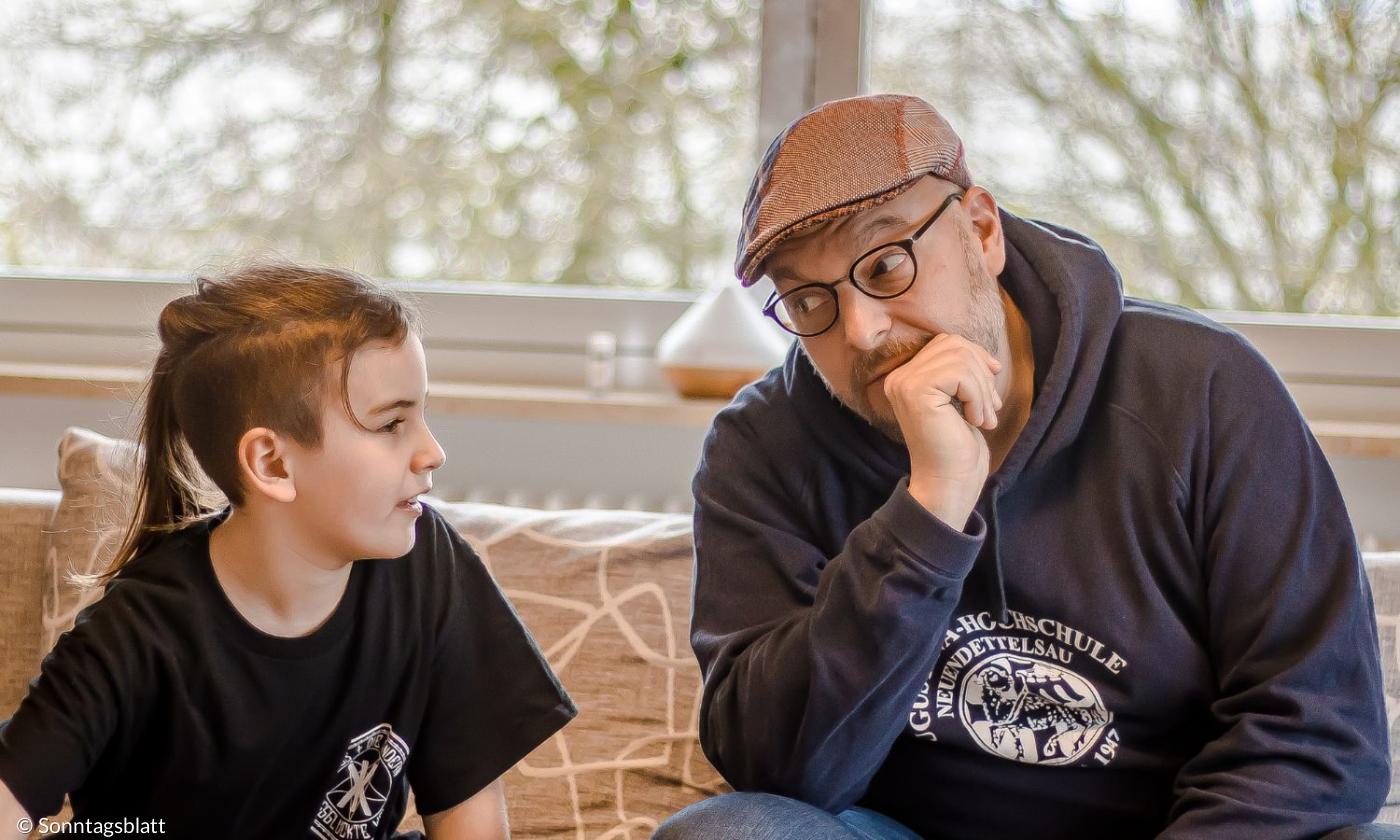 Ein Junge und ein Mann sitzen nebeneinander