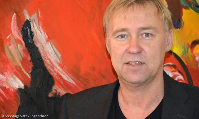 Der Regensburger Theater-Intendant Jens Neundorff von Enzberg vor einem Gemälde in seinem Büro.