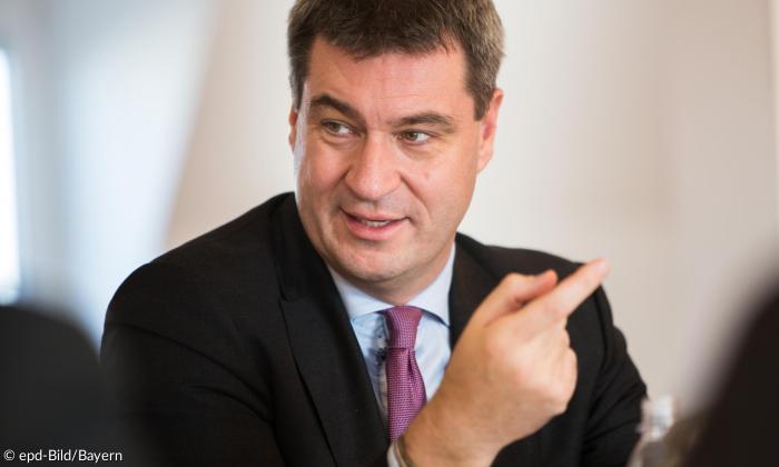 Mann mit Anzug und braunen Haaren schaut zur Seite