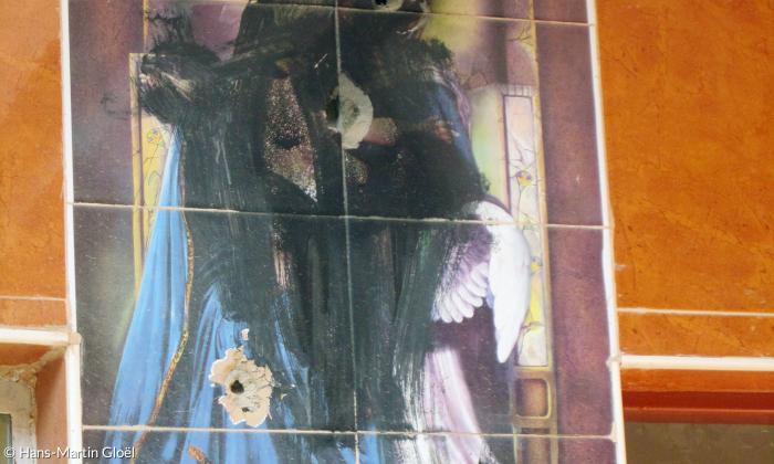 Beschossen und geschwärzt: ein christliches Bild an einer Hausfassade in Batnaya.
