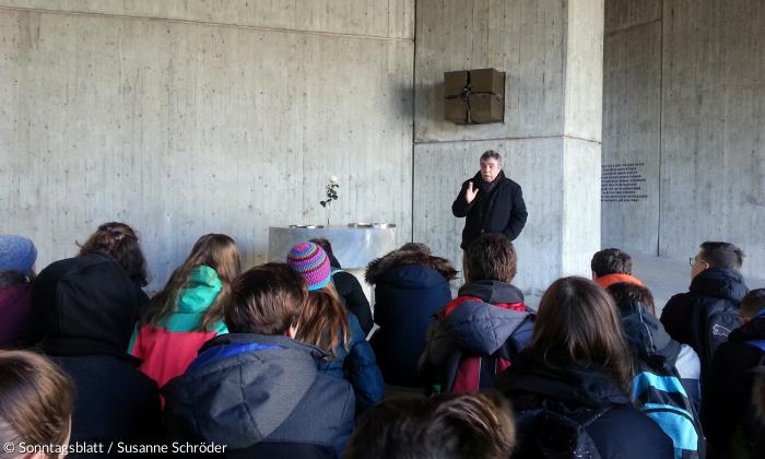 Diakon Klaus Schultz mit einer von ihm geführten Gruppe im Kirchenraum der evangelischen Versöhnungskirche auf dem Gelände der KZ-Gedenkstätte Dachau.