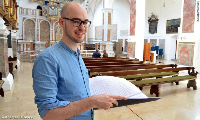 Patrick T. Schäfer mit der Partitur zu seiner Oper in der Kirche St. Anna.