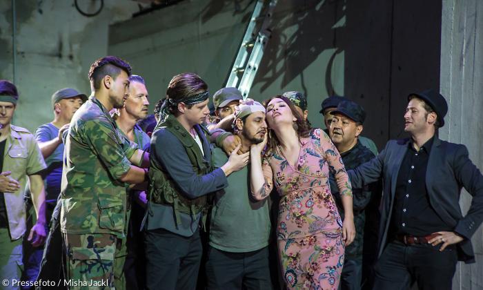 »Carmen« im »Mixed Munich Arts«: Carmen (Cornelia Lanz) umgarnt Zuniga (Ahmad Shakib Pouya) – bewundert von Soldaten und den Schmugglern Dancaïro (Tom Amir, mit Stirnband) und Remendado (Yoed Sorek, ganz rechts).