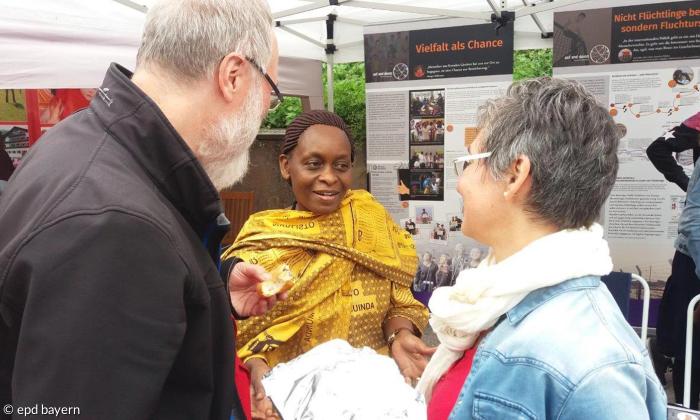 Margaret Obaga (Mitte) an einem Infostand von Mission EineWelt. 