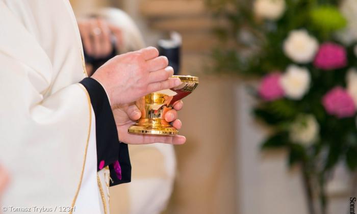 Eucharistie - Abendmahl: Priester mit Patene und Oblate.