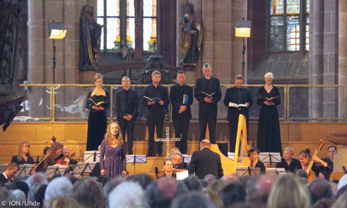 Menschen stehen in einer Kirche mit Büchern in der Hand