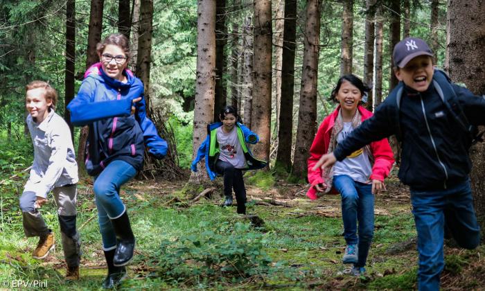 Kinder rennen im Wald. 