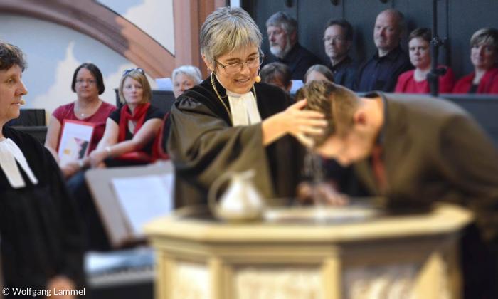 Regionalbischöfin Dorothea Greiner tauft iranische Geflüchtete.