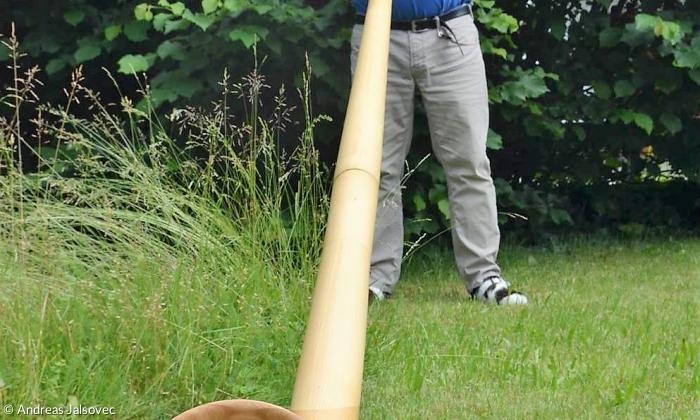 Alphornbauer Thomas Rupp spielt in seinem Garten in Seeg im Allgäu