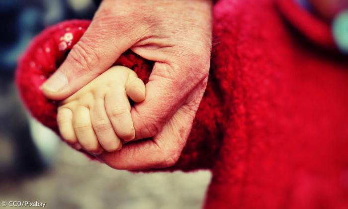 Hand eines Kindes in der Hand eines Erwachsenen 