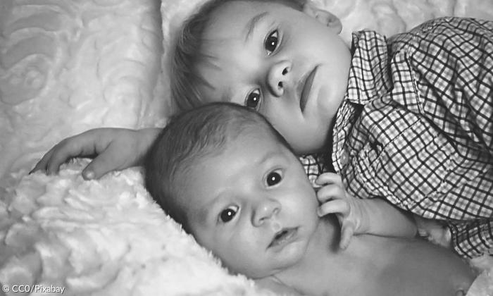 Zwei Kleinkinder liegen im Bett