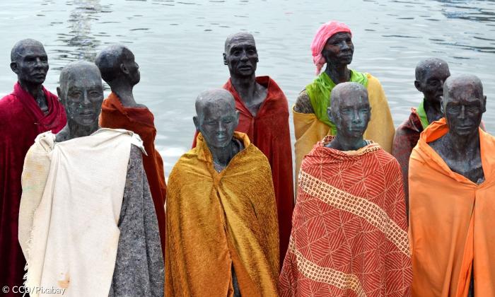 Skulpturen von Flüchtlinge mit Wasserhintergrund