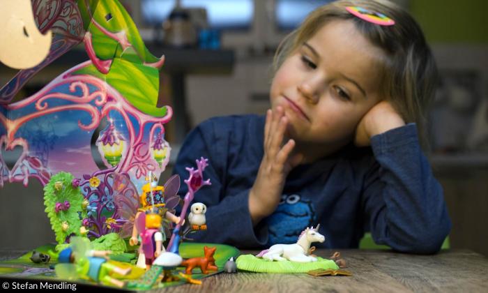Kind mit Playmobil Einhorn