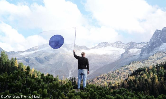 One World Flag vor Bergpanorama 