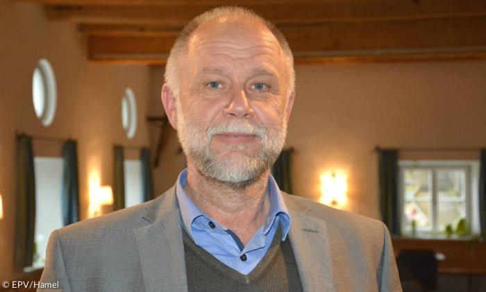 Ein Mann im grauen Anzug mit blauem Hemd