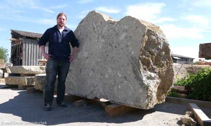 Steinmetz Matthias Wittner vor einem unbearbeiteten Suevit-Block