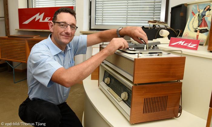 Martin Schramm, Amtsleiter für Stadtarchiv und Museen der Stadt Fürth, demonstriert im Rundfunkmuseum Fürth einen alten, analogen Plattenspieler.