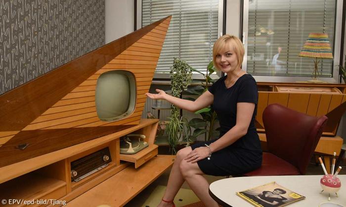 Jana Stadlbauer, Leiterin des Rundfunkmuseums Fürth, neben der Fernsehwand "Kuba-Komet" im stylischen Holzdesign