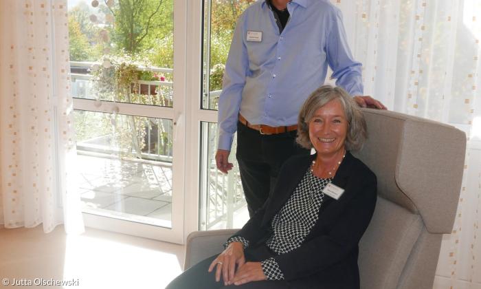 Leiterin der Einrichtung Sabine Wittmann in einem Ruhesessel eines der Gästezimmer mit Stephan Powils, der das stationäre Hospiz in Nürnberg-Mögeldorf leitet