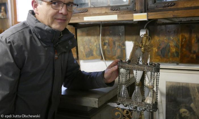 Gemeindepfarrer Thomas Braun mit einer Kanzel-Sanduhr