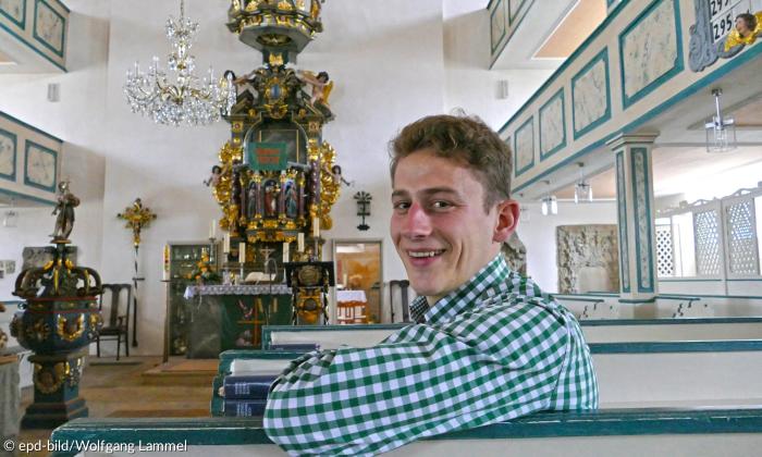 Ein Mann im karierten Hemd in einer Kirche