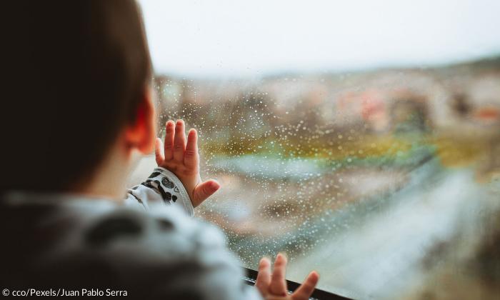 Kleinkind am Fenster mit Regen