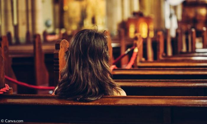 Eine Frau sitzt in der Kirche