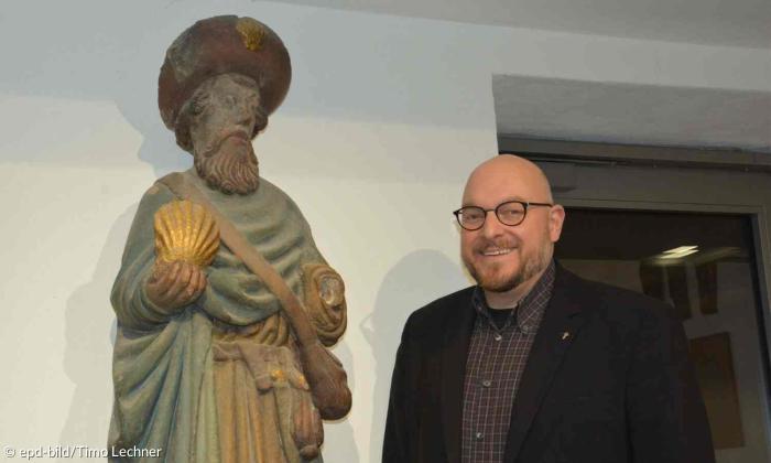 Hannes Schott mit einer Statue des Heiligen Jakobus
