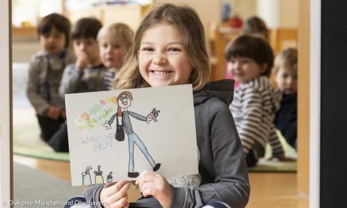 Ein Mädchen hält ein Bild auf dem eine Person gemalt ist. Dabei stehen die Worte: Wir suchen dich.