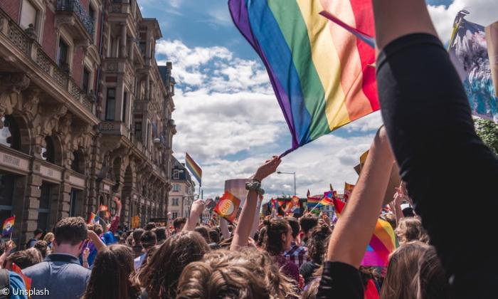 Demonstrierende mit Regenbogenflagge