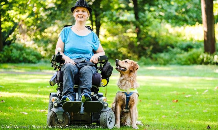 Eine Frau im Rollstuhl mit ihrem Assistenzhund