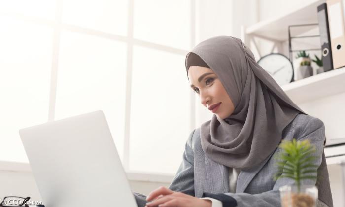 Eine Frau mit Kopftuch am Laptop