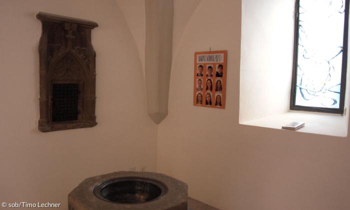 Ein Taufbecken in einer Ecke der Kirche.