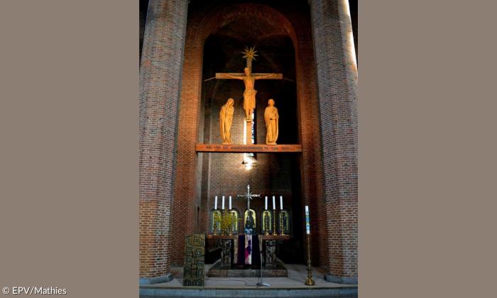 Der Altar der Reformations-Gedächtniskirche Nürnberg mit einer Jesusfigur, die an ein Kreuz genagelt ist, darüber.