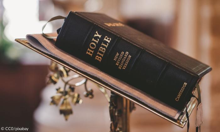 Eine Bibel auf einem Tischchen.
