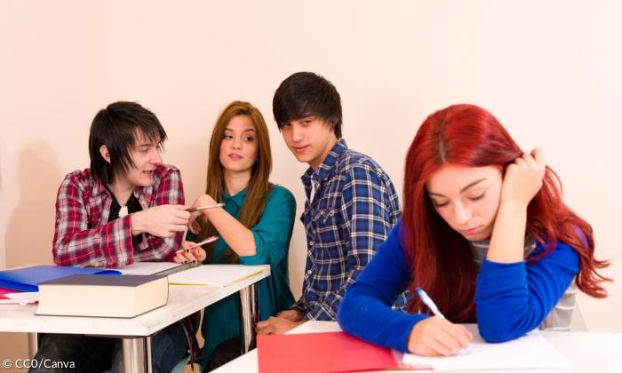 Drei Mitschüler*innen mobben eine Schülerin