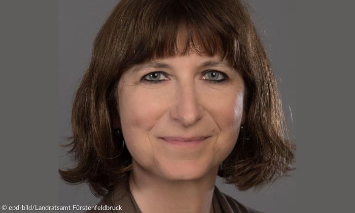 Eine Frau mit kinnlangen Haaren und Pony schaut in die Kamera.