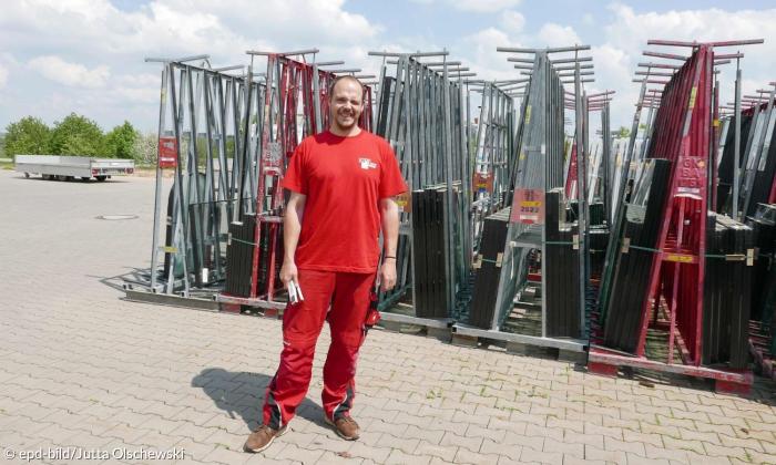 Ein junger Mann in roter Arbeitskleidung 