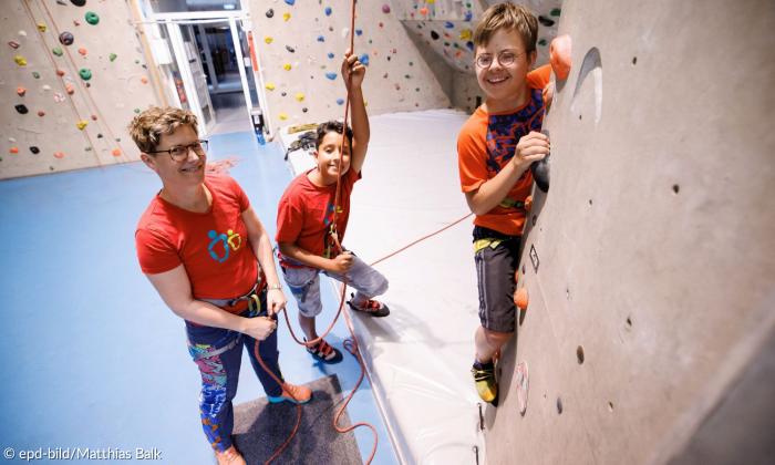 Eine Frau und zwei Kinder an der Kletterwand