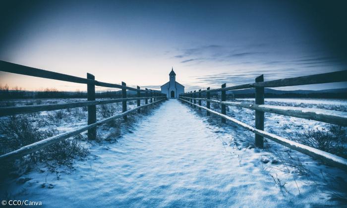 Ein schneebedeckter Weg führt zu einer kleinen Kirche