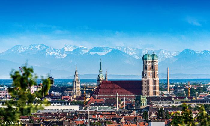 Die Münchner Frauenkirche, dahinter die Alpen