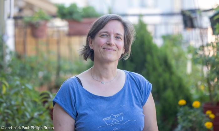 Eine Frau mit hellbraunen Haaren in einem blauen T-Shirt
