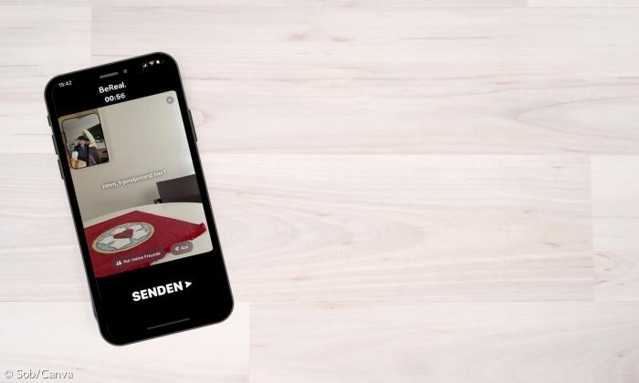 Ein Smartphone liegt auf dem Tisch. Auf dem Display ist die App BeReal geöffnet. 