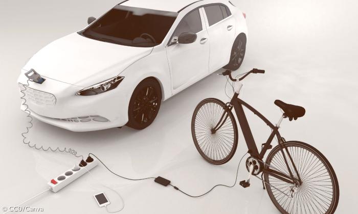 Ein E-Auto und ein E-Bike an der Steckdose