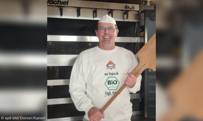 Ein Bäcker steht vor einem Backofen