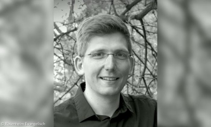 Ein Mann mit Brille vor einem Baum