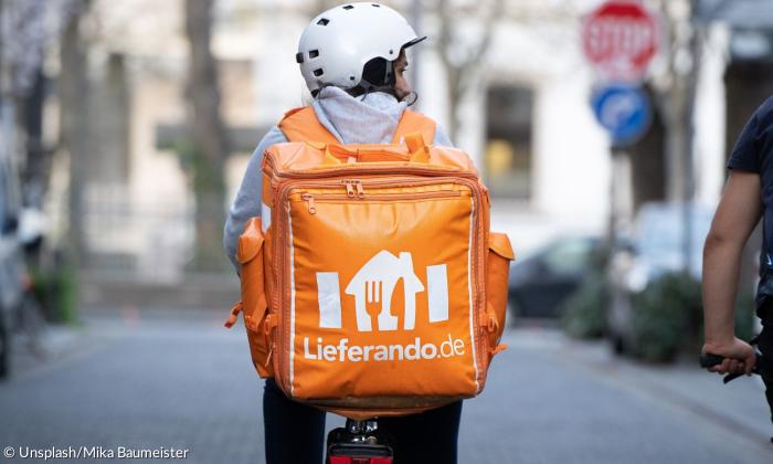 Ein Mann auf einem Rad mit Lieferando-Rucksack