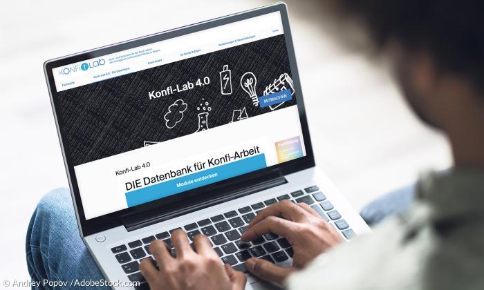 Ein Mann hat einen geöffneten Laptop auf dem Schoß und tippt auf den Tasten