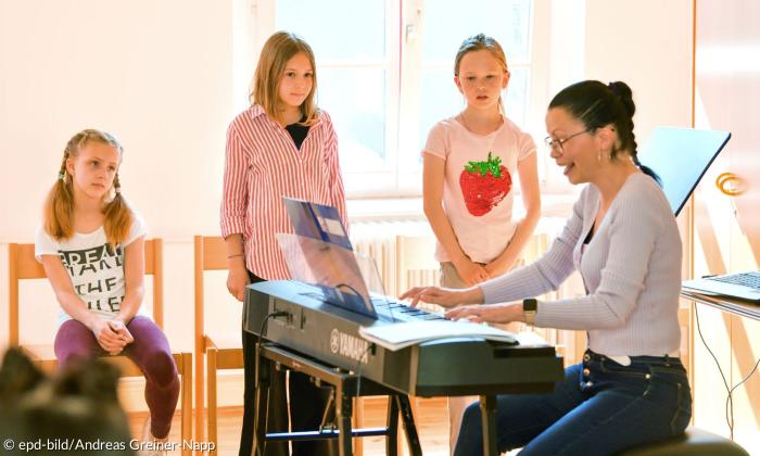 Drei Kinder und eine Frau am Keyboard