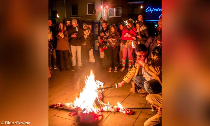 Menschen um ein brennendes Feuer